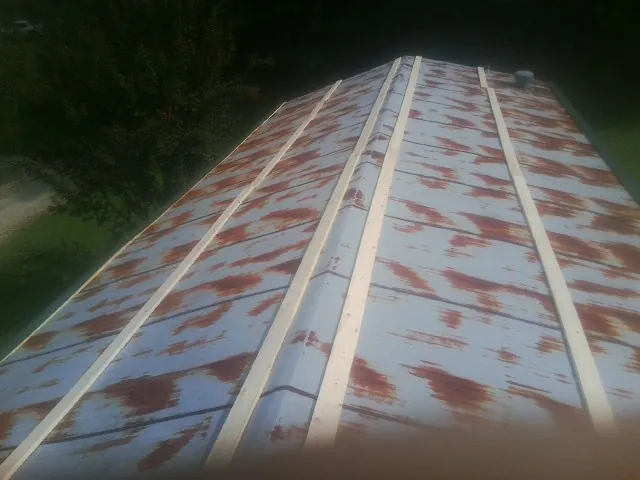Rusted metal roof panels with new wood purlins before replacement — Storm Damage Roof Repair in Pocono Lake by Roofing Brothers