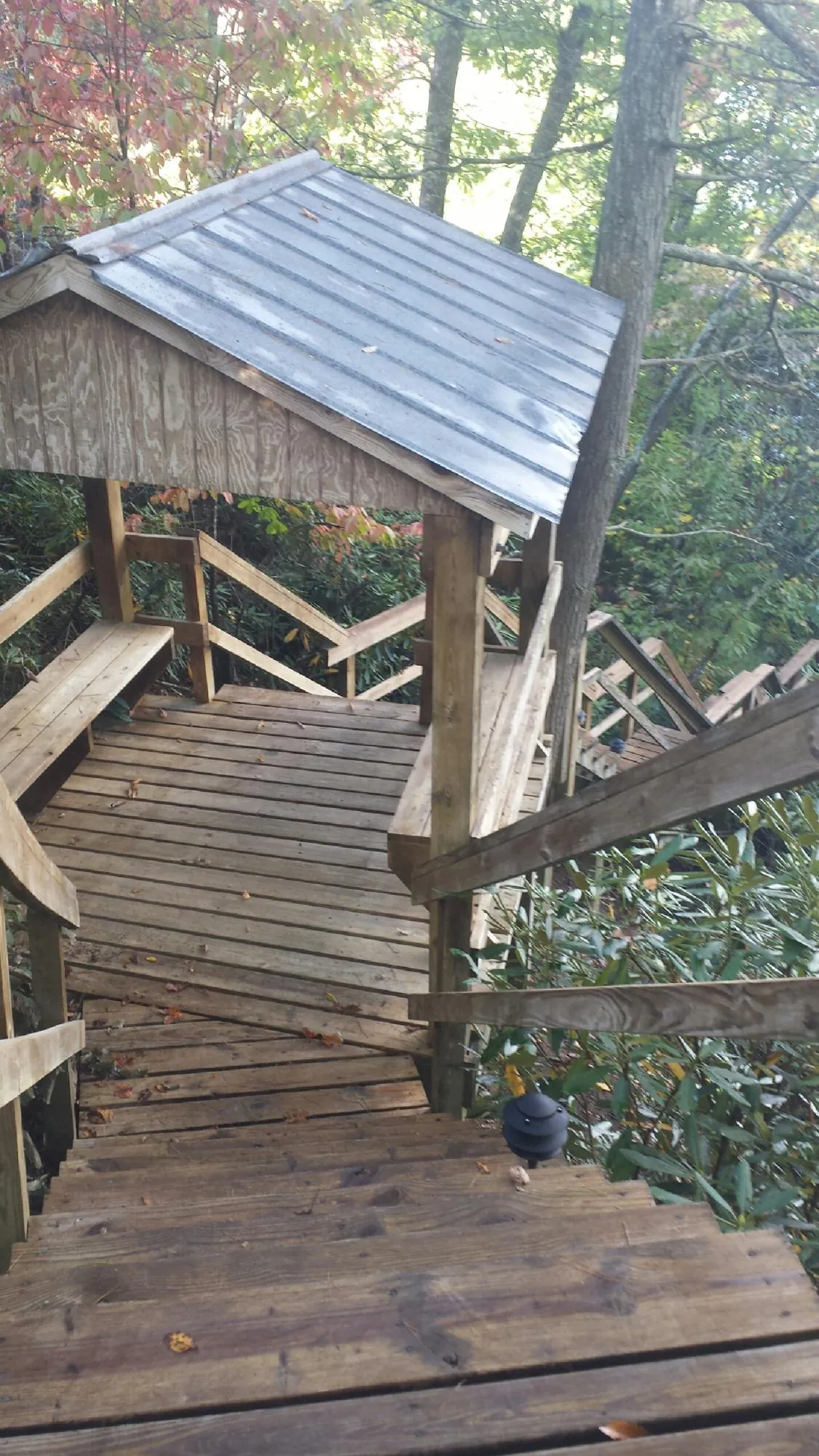 Metal roofed shelter over wooden steps on a wooded walkway — Skylight Repair & Installation work by our crew in Pocono Lake