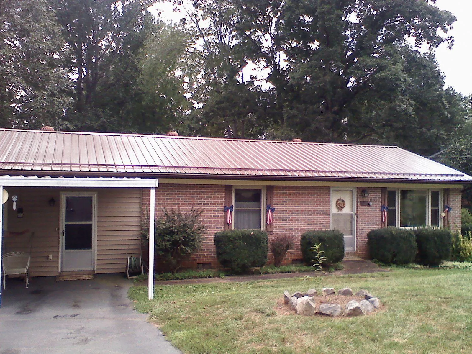Bronze metal roof and carport on a brick ranch home — Roof Repair work by our crew in Pocono Lake